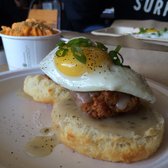 Honey Butter Fried Chicken - Chicago, IL, United States. Fried chicken on a biscuit with gravy and a fried egg. Pimento mac & cheese in the background. Both excellent!