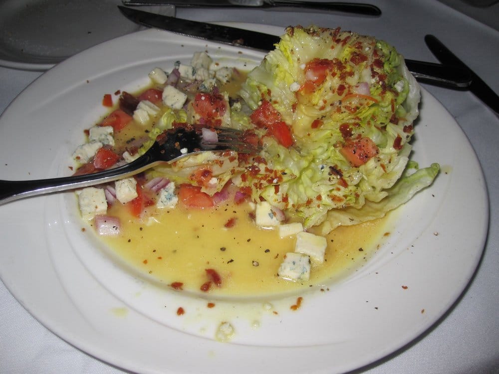 Wedge of lettuce with cheese, crispy pancetta, red onions