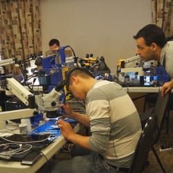 Rossmann Repair Group - New York, NY, United States. Louis coaches student learning how to repair logic boards at Practical Board Repair School.